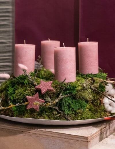 Adventskranz auf Teller mit rosanen Kerzen